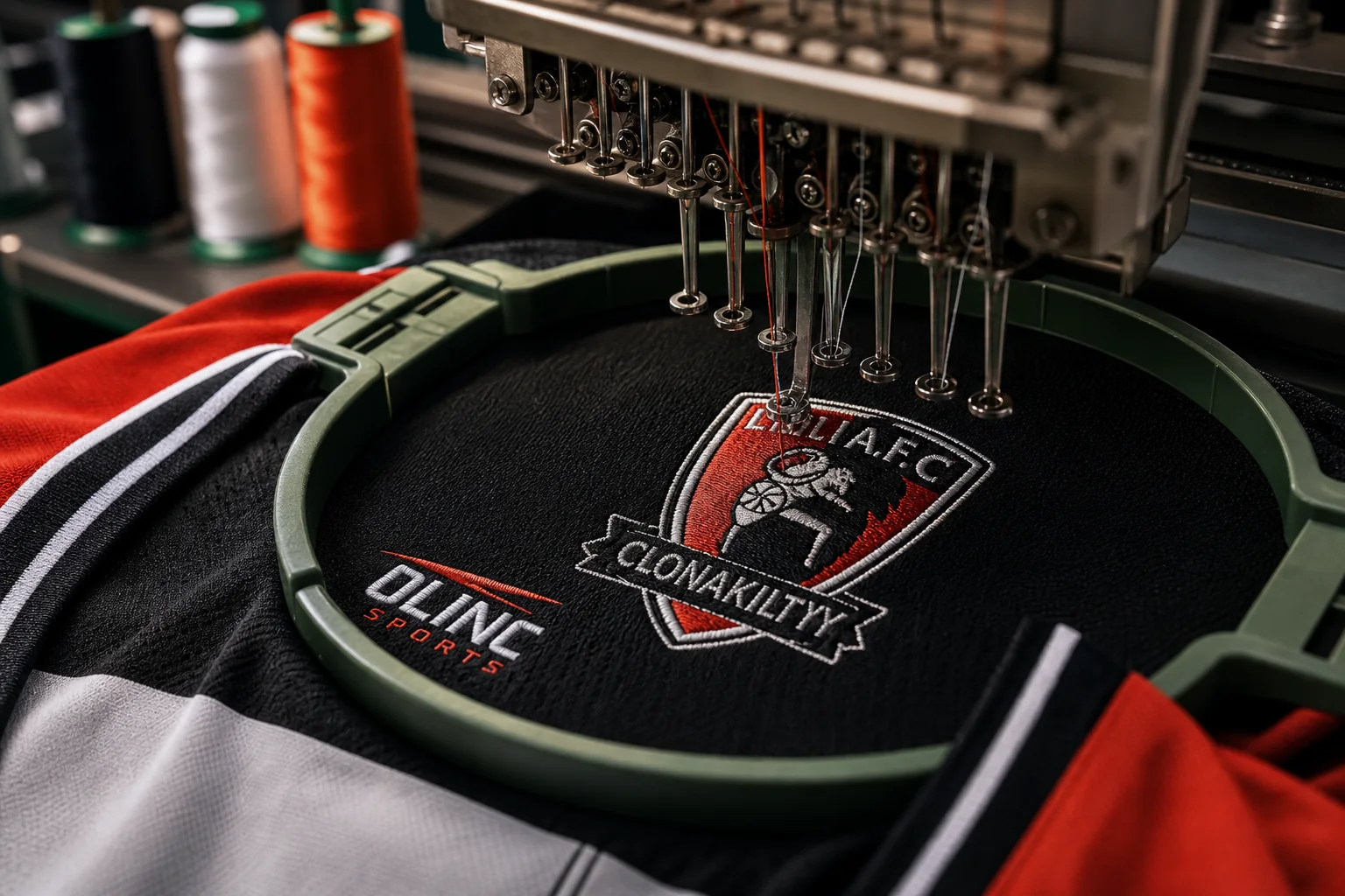 Embroidery machine stitching a club crest onto a sports jersey panel