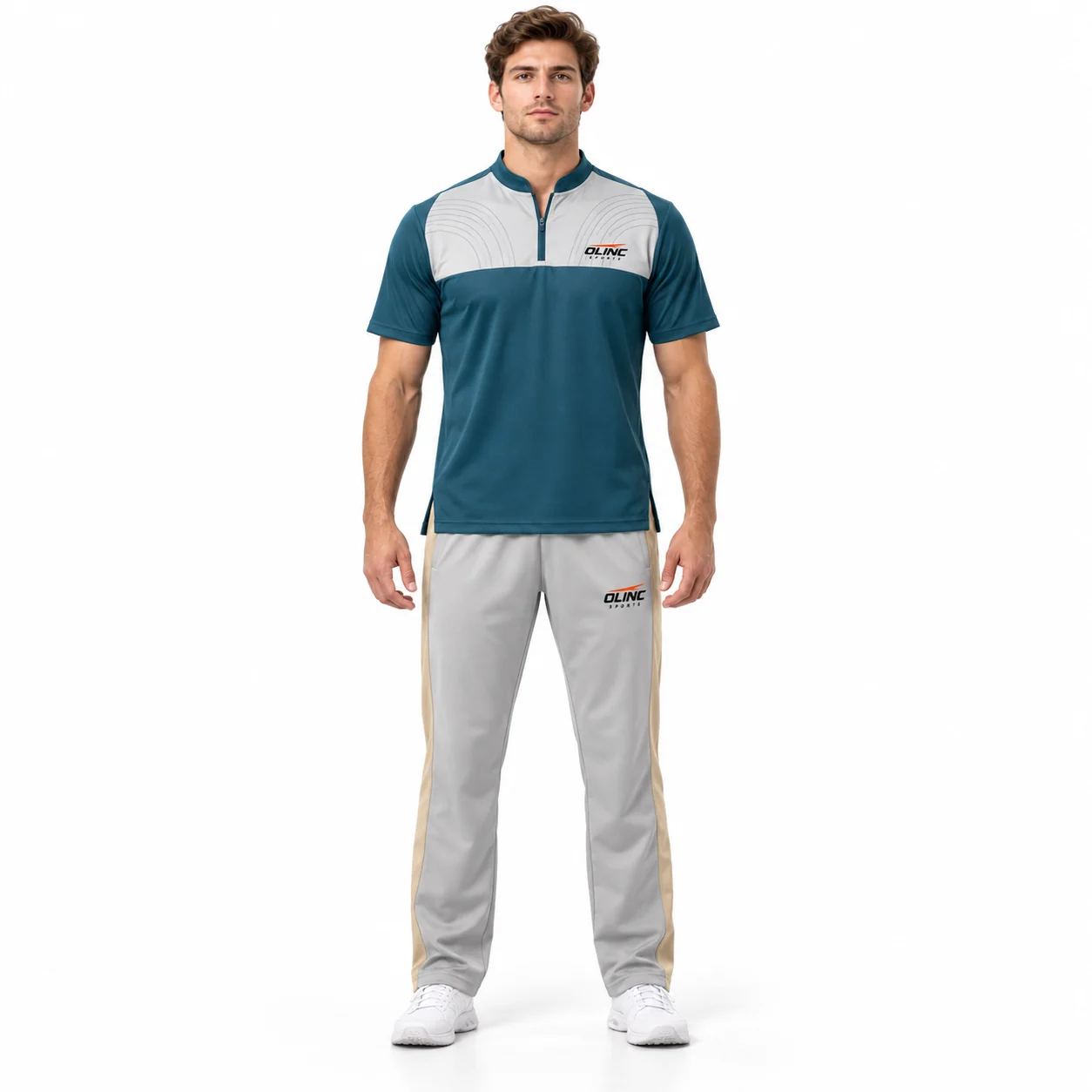 Cricket Fieldnote Zip-Neck Kit front design view showing deep-teal short-sleeve shirt, pale-gray chest yoke and sand trouser side panels