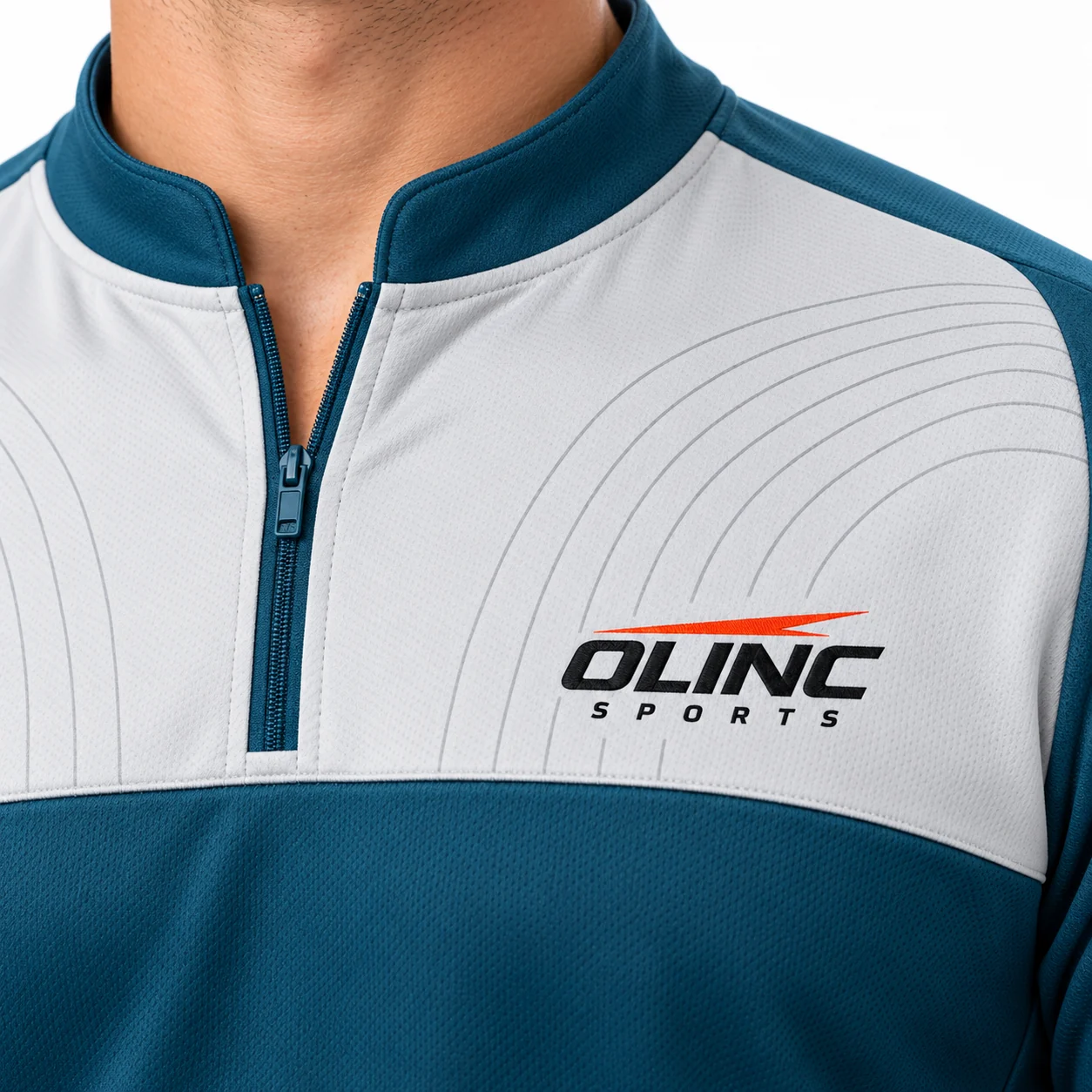 Cricket Fieldnote Zip-Neck Kit zoom design view showing deep-teal short-sleeve shirt, pale-gray chest yoke and sand trouser side panels